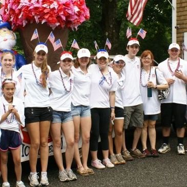 A group photo of Benson's employees and family members decked out in patriotic gear ready to march i