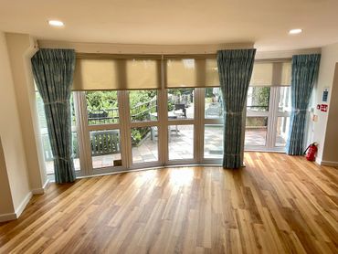 New dress curtain with motorized roller blinds in sitting area at the care home