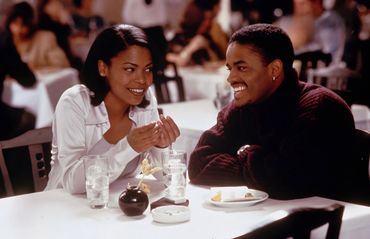 Couple smiling while dining at a restaurant.