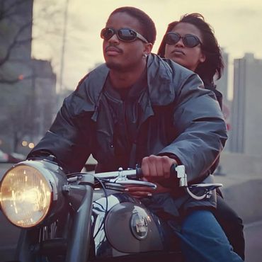 Couple riding a motorcycle with sunglasses in the city.