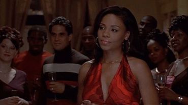 Woman in red dress at a social gathering.