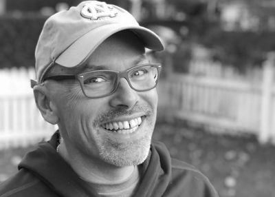 Black and white image of Dare to Be Films founder Adam Reist smiling