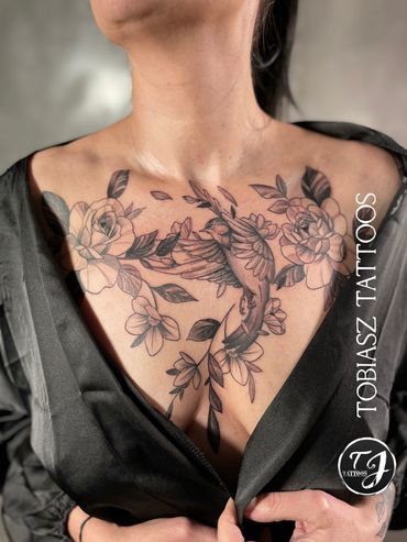 chest tattoo of a small bird with large flowers 3