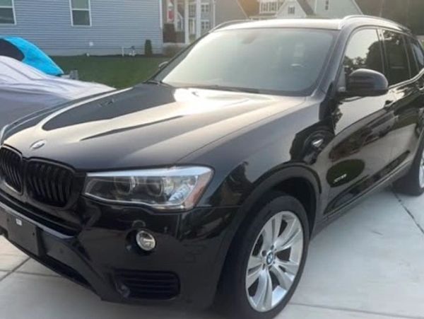 Black BMW SUV parked on a driveway.