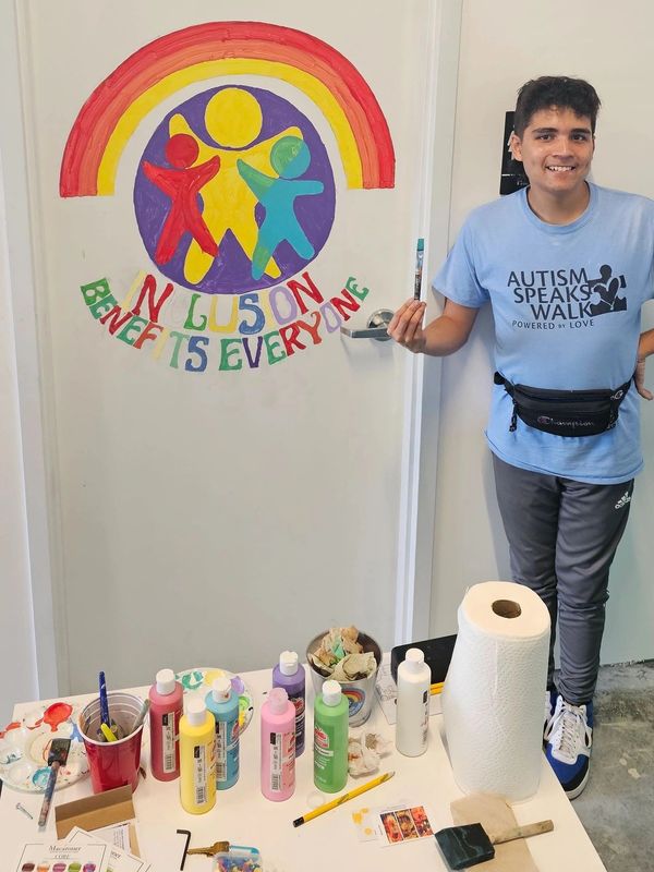 Kyle Segura painting a mural.