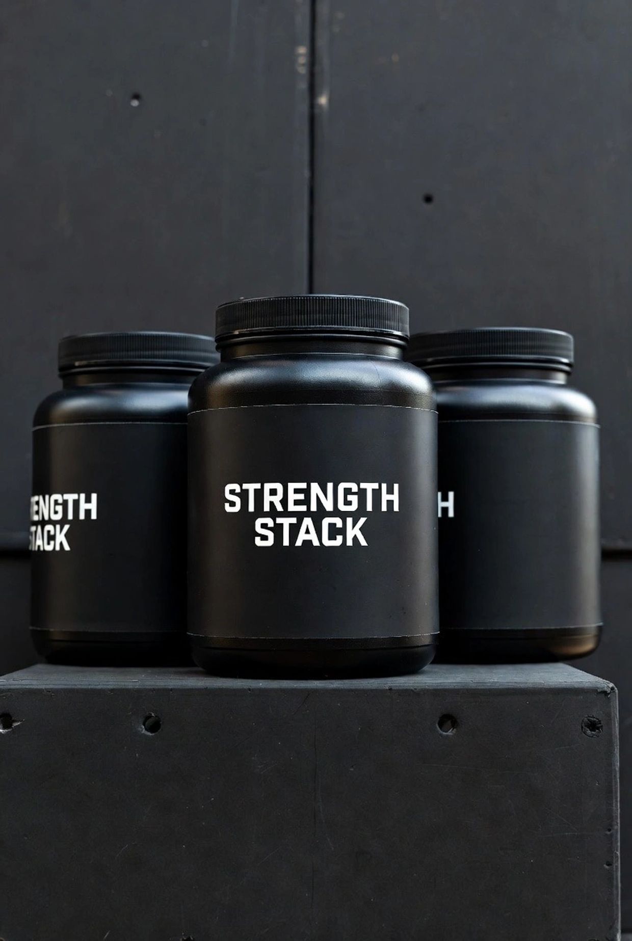 three black plastic containers with the words strength stack in white 