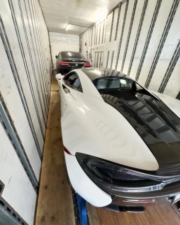 Exotic cars loaded inside an enclosed semi transport. 