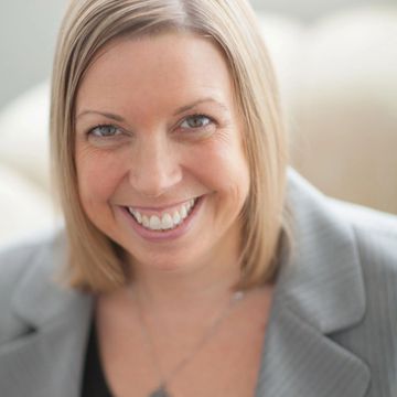 Headshot of Summer Stinson wearing a grey business suit and necklace. She is smiling.