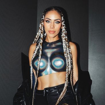 Woman with long braided hair and metallic body paint top.