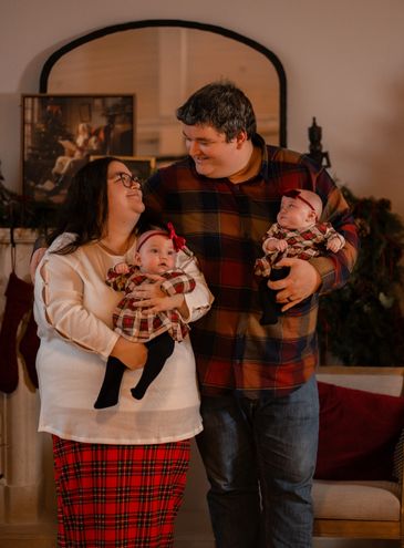 Smiling couple holding twin babies in festive setting at Park hill studios in cambridge ontario
