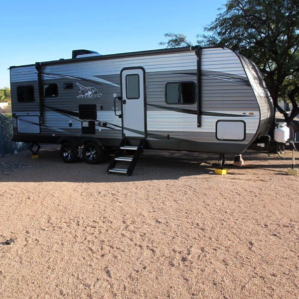 electric trailer dolly installed on travel trailer in dirt.