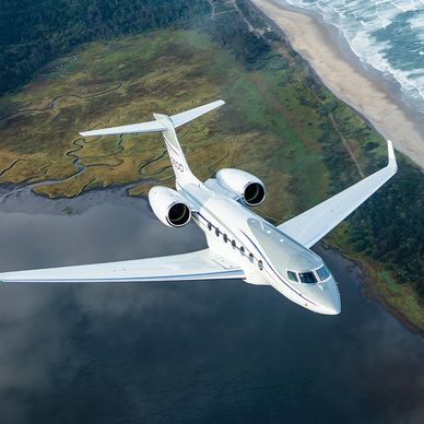 private jet flying over land and water