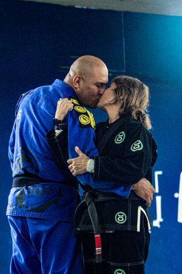 Casal se beijando usando quimonos de jiu-jitsu.