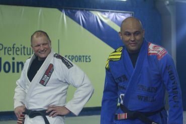Dois homens em kimono durante treino de artes marciais.
