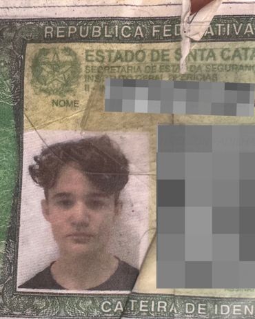 Old identification card with a young man's photo and blurred personal details.