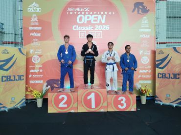 Four Brazilian Jiu-Jitsu competitors on podium at Joinville Open 2026.