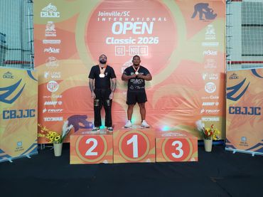 Two men on a podium at Joinville SC International Open Classic 2026 awarding ceremony.