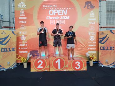 Three male athletes on a winners' podium at Joinville Open Classic 2026.