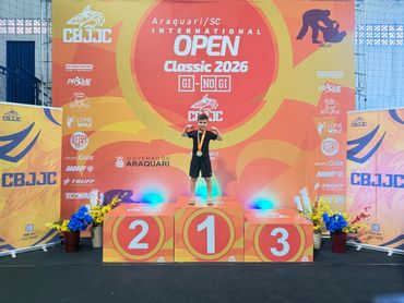 Champion standing on the first place podium at the 2026 International Open event.