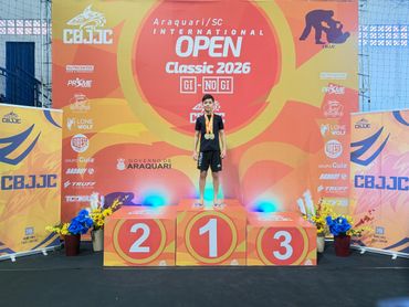 Young athlete standing on first place podium at CBJJC Open 2026 event.