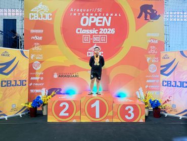 Young athlete stands on the first-place podium at the 2026 CBJJC International Open event.