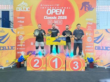 Winners pose on podium with trophies and prize check at BJJ Open Classic 2026.