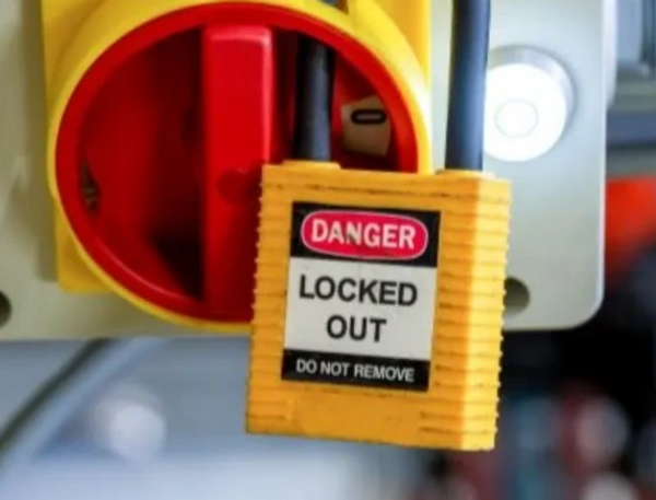 Yellow lock with danger sign indicating locked out status on electrical switch.