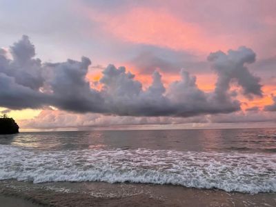 Sunset over the ocean with dramatic clouds.