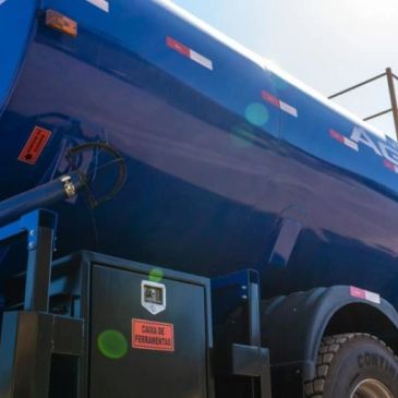 Close-up of a blue tanker truck under bright sunlight.