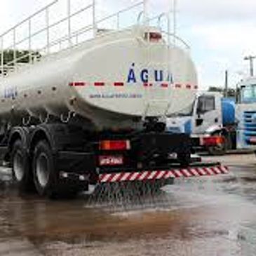 Water tanker truck spraying water on the road surface.