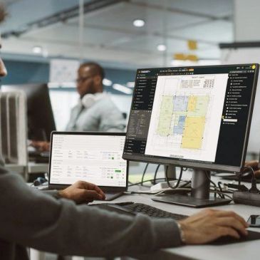 Person working on architectural plans on a computer at an office.