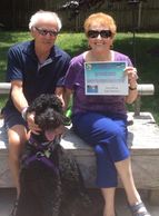 Clients from dog training class. Holding their dog's graduation certificate.