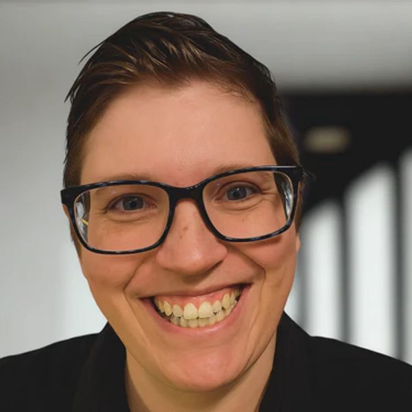 Woman with short hair and glasses smiling
