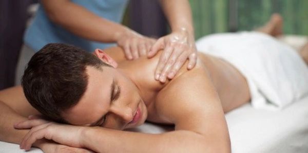 Man receiving a relaxing shoulder massage while lying down.