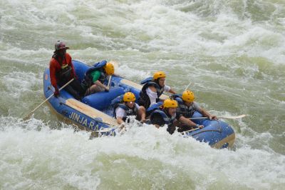 Group white-water rafting on turbulent river.
