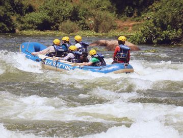 Group rafting in a river with safety gear.