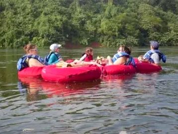 Group of people tubing on a river.