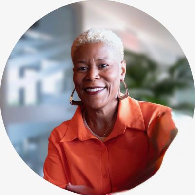 Smiling woman with short white hair and orange shirt.