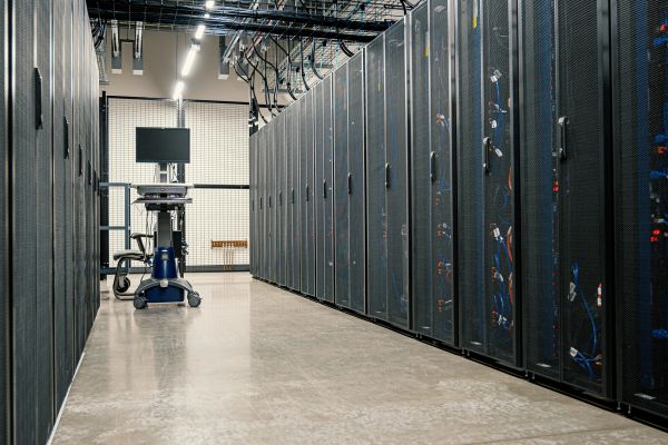 Data center aisle with server racks and a monitoring station.