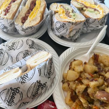 Plates with breakfast sandwiches and a side of seasoned potatoes.