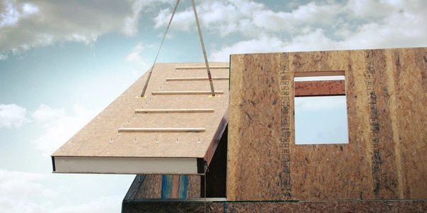 A structural insulated panel being installed as a roof panel on a construction build
