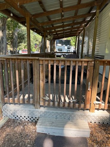 Wooden porch entrance with steps and railing.