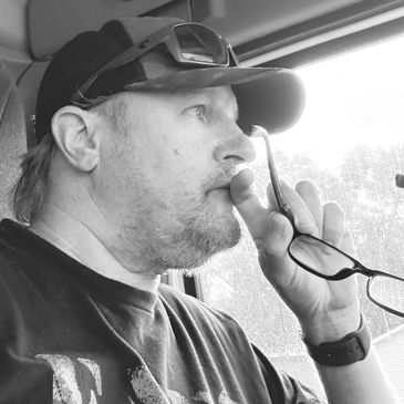 Man deep in thought holding glasses near his face.
