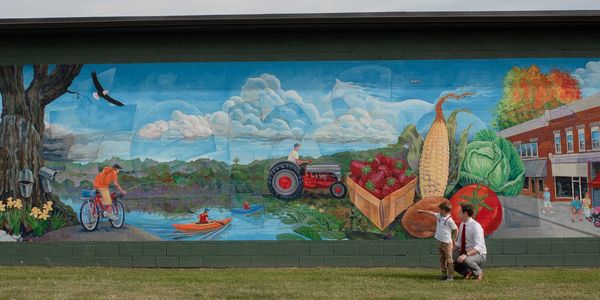 Darrell and his son looking at a mural of Waterford, Pennsylvania on the Waterford Borough Building