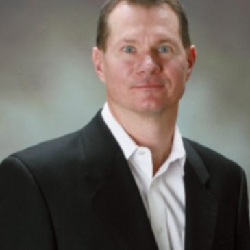 Portrait of a man in a dark suit jacket.