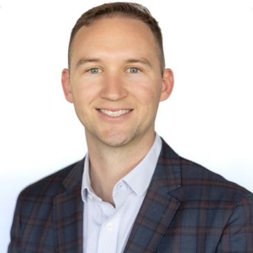 Smiling man in a checked suit jacket.