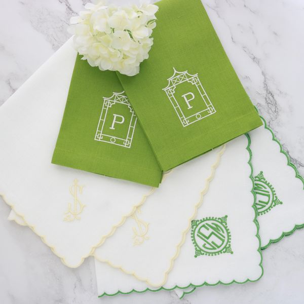 group of scalloped linen dinner napkins and guest towels, monogrammed in yellow and green