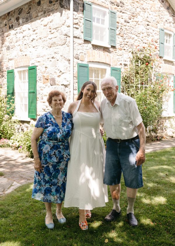 Three generations of family smiling outdoors.