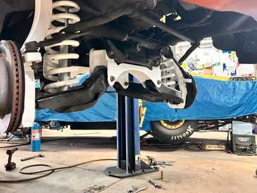 Front suspension and coil spring of a vehicle in a garage.