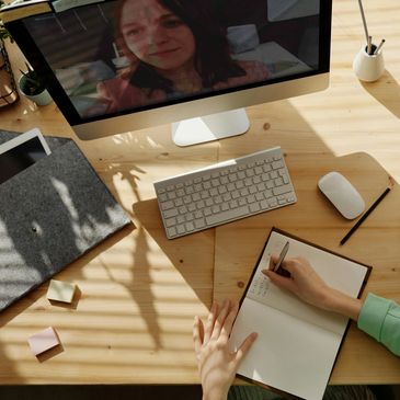 Person video chatting and taking notes.